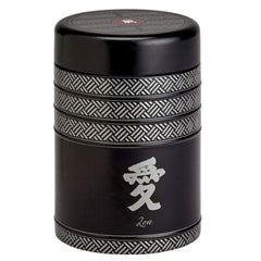 Black cylindrical tea storage tin with Asian characters.