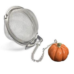A stainless steel tea ball with a chain attached to an orange pumpkin charm. 